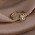 Detailansicht eines goldfarbenen Halo-Rings mit rechteckigem Zirkon auf Seidenhintergrund - 4# Quadratischer Stil