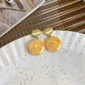 Detail van geborsteld gouden oorbellen met crème marmeren hars hangers op een wit bordje - Melkwit Patchwork Cirkel Stijl (6# 12060)