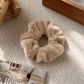 Close-up of soft khaki plush scrunchie on beige fabric with cozy autumn aesthetic - B Coffee