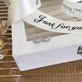 Close-up of heart-shaped stud earrings with micro-pave cubic zirconia in gift packaging - B Silver