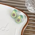 Macro detail of avocado stud earrings with fuzzy flocked texture on a white plate - Avocado