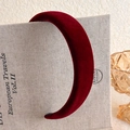 Detail view of the plush burgundy velvet headband texture on a decorative book background - Dark Burgundy Padded Velvet Style (18# 27389A)