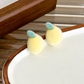 Macro detail of sweet yellow flocked lemon stud earrings on white ceramic tray - Lemon