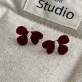 Nahaufnahme von bordeauxroten beflockten Schleifenohrringen mit zentralem Schmuckstein - Schleife Strass Stil (46#26353A)