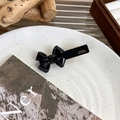 Detailansicht einer handgefertigten schwarzen Acetat-Schleife mit eleganter Goldprägung - Schwarze Schleife