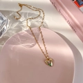 Détail d'un pendentif cœur avec tulipe rose sur une chaîne dorée et fermoir mousqueton - Style Tulipe à Chaîne en Métal