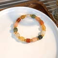 Dettaglio di perline di pietra cilindriche colorate su un piatto di ceramica bianca - Stile Cilindro
