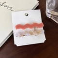 Gros plan de pinces à cheveux ondulées rose et marbre sur une table en bois foncé - Ensemble Rose Foncé (B)