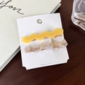 Détail de barrettes à cheveux ondulées en acétate crème et marbre sur carte support - Ensemble Jaune (C)