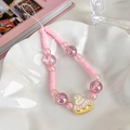 Dragonne de téléphone perlée rose avec breloque lapin sur une assiette en céramique - Style Gâteau Lapin / Rose