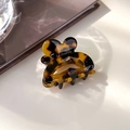 Primer plano de pinza de pelo de mariposa en carey con letras doradas de Barrette la France - Carey Oscuro