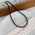 Detail van vintage kralenketting met hartvormige zirkoon hanger op juwelendoos en keramiek - Zwart