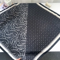 Macro detail van de zijden sjaal met paisley en witte stippen met contraststiksel - Zwart