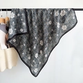 Macro detail of camellia flower print on soft square scarf with woven texture edges - Black / 90x90cm