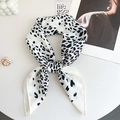 Détail d'un foulard en soie à imprimé léopard avec des accessoires de mode élégants - 65x65 / Blanc