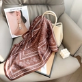 Détail d'un foulard en soie marron à motif floral sur un canapé au ton élégant - 65*65 / Marron