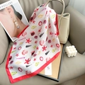 Detalle de un pañuelo de seda con estampado marino rojo sobre un bolso beige - Talla única / Rojo