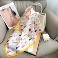 Detalle de un pañuelo de seda con estampado de estrellas de mar sobre un bolso de mano chic - Talla única / Amarillo