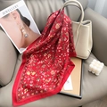 Detail of red floral silk scarf tied on a beige bucket bag in a stylish home setting - Red / 65x65cm
