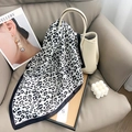 Foulard en soie imprimé léopard classique drapé sur un sac à main dans un décor chic - Gris