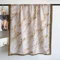 Elegante sjaal van katoen en linnen met herfstbladprint hangend aan een hanger - Groene Rand