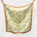 Détail d'un foulard carré en soie à imprimé citron avec des fruits jaunes et bordure en satin - Kaki