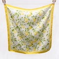 Détail d'un foulard en soie carré avec imprimé citron et bordure jaune en finition satinée - Jaune