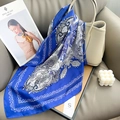 Royal blue paisley silk scarf with purple border draped on a gray leather sofa - 65x65cm / Blue