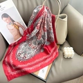 Classic red paisley silk square scarf elegantly draped over a leather bag in a lifestyle setting - 65x65cm / Red
