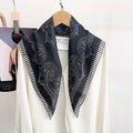 Close-up of elegant black and white polka dot silk scarf tied on a white shirt collar - Black
