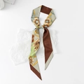 Detail of floral and chain print skinny silk scarf on white textured paper background - Four Flower Chain - Brown