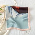 Detailed close-up of abstract mountain print silk scarf on a white dress with tulips - Cultural Elegance