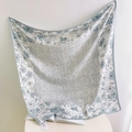 Detailed macro view of light blue floral faux silk scarf with elegant wide-stitched borders - Light Blue