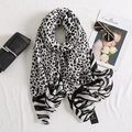 Gedetailleerde textuur van sjaal met luipaard- en zebraprint met stijlvol merklabel en items - Grijswit