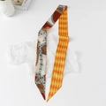 Detailed macro view of a dual-sided skinny silk scarf with vintage pearl and chain patterns - Sky Lock - Brown Red