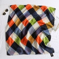 Detailopname van kleurrijke sjaal met geometrisch patroon op linnen achtergrond - Oranje Blauw