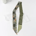 Close-up of geometric floral silk ribbon scarf with horsebit print on white background - Geometric - Green