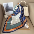 Détail d'un foulard en soie de luxe avec imprimé chaîne drapé sur un sac à main blanc - Bleu