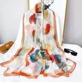 Silky beach shawl with colorful ginkgo leaf print and orange border on wooden hanger - Colorful Ginkgo Leaf (YRS149)