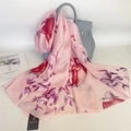 Eleganter rosa Seidenschal mit Magnolienblüten an einer Handtasche drapiert - Pfirsich