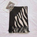 Detailed macro view of zebra pattern scarf with dense black tassel fringes on white fabric - Black