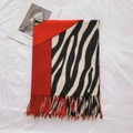 Detail van gebreide sjaal met zebrapatroon, rode franjes en dikke textuur - Rood