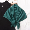 Detail eines weichen dunkelgrünen Leinenschals auf einer minimalistischen weißen Fläche - Stil 11