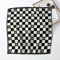 Close-up of black and white checkerboard velvet scarf with floral pattern and accessories - Black