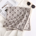Flat lay of floral square silk scarf with geometric patterns on magazine and sunglasses - Off White