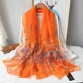 Detailed macro of orange paisley print scarf with breathable lightweight silk texture - Orange Paisley Style