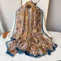 Close-up of floral print chiffon scarf with teal border on white shirt and marble surface - Ink Blue Floral