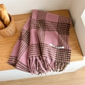 Pink and brown checkered plaid scarf with soft tassels and brand label on wood table - Pink