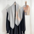 Detail of silk satin scarf with geometric pink and beige patterns on black dress - Gray Edge