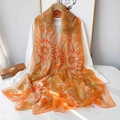 Detail of vibrant orange floral chiffon scarf draped elegantly over a wooden hanger - Orange Yellow Sunflower Style